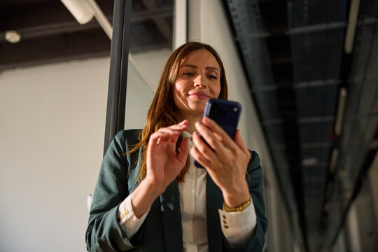Beautiful woman holds a mobile phone inside the corporation