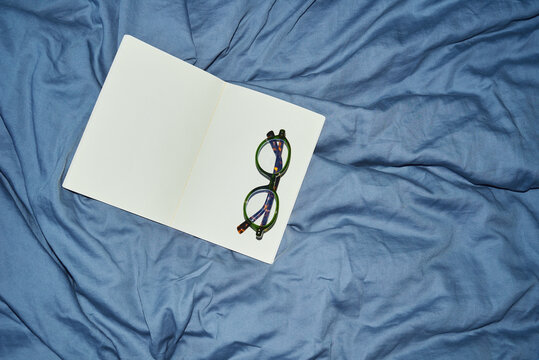 Dairy with glasses on blue bedding
