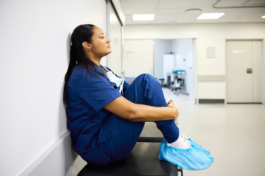 Tired and overwhelmed Nurse Rests in Hospital Corridor