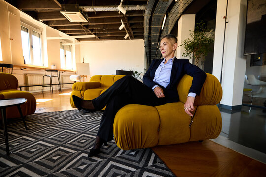 Senior woman sits back in a corporate lobby