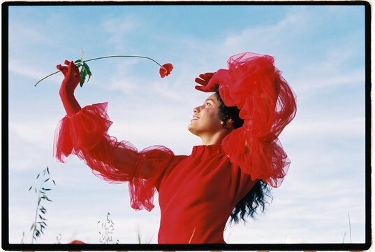 Woman in red dress holding flower 