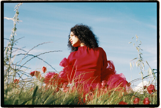 Woman in red dress in poppy field