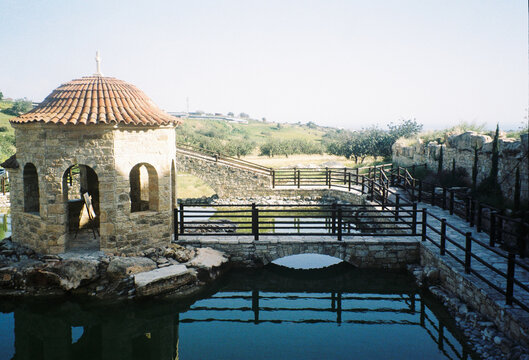 Stone Gazebo by Water Body in Sunny Landscape With Bridge