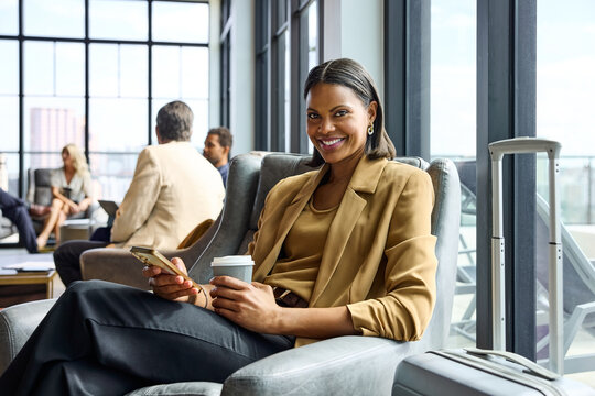 businesswoma sits in a chair holding a coffee cup