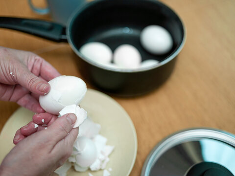 woman peeling hard boiled egg