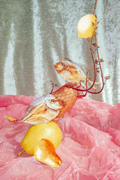 Art piece with fish and fruit arranged on colorful background