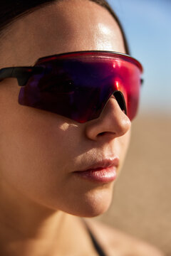 Woman wearing red sunglasses on a sunny beach