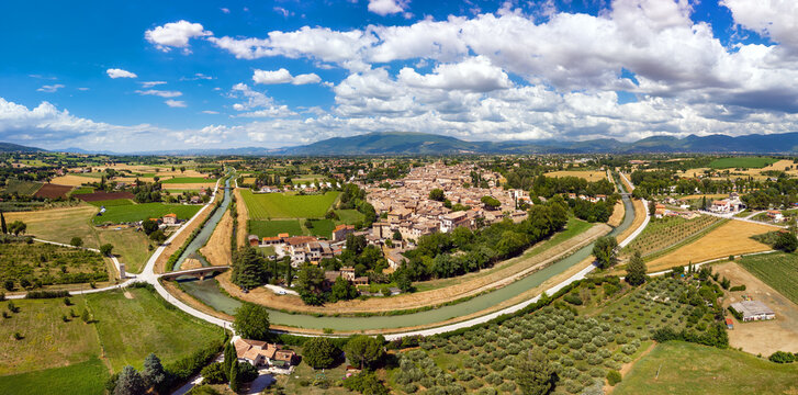 Bevagna medieval borgo aerial panorama with green hills and river bend, Perugia, Umbria, ItalyAuthentic Italian walled town. Ultra high resolution, world print quality, copy space sky