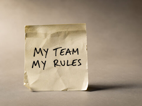 Folded sticky note with "my team my rules" written on it my team my rules handwritten business management organization dedication collaboration teamwork