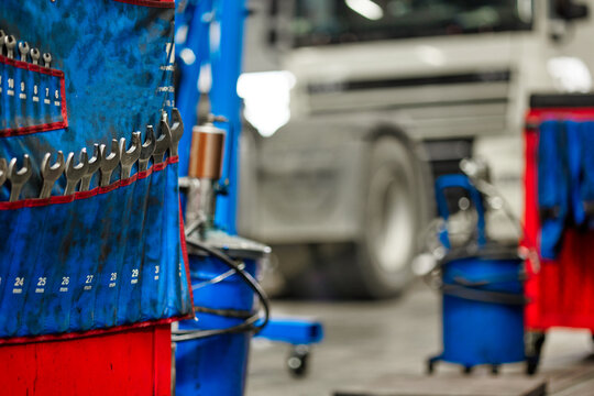 This image features a variety of professional wrenches hanging neatly in a truck service garage. Perfect for showcasing tools essential for mechanics and automotive services.