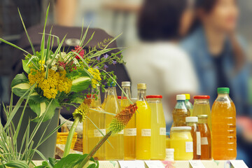 Bottled homemade syrups and fresh flowers on a stall at the Hermanak farmers market in Prague Holesovice. Features top right copy space. Local food culture, community gathering, and organic lifestyle. © arazu
