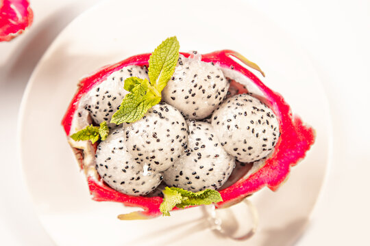 Dragon fruit balls in half shell with mint garnish