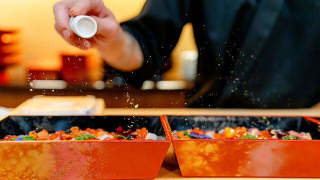 Chef sprinkling gold over chirashi sushi in Tokyo
