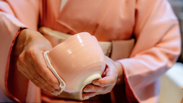 Japanese woman in kimono holding tea bowl close-up