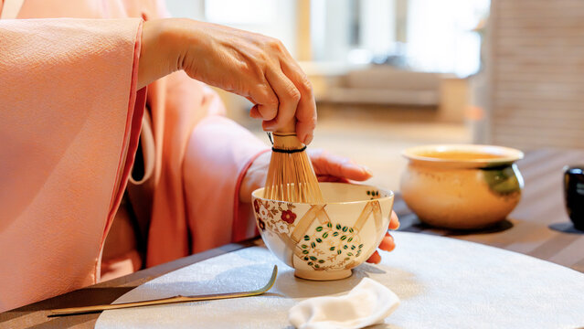 Japanese woman whisking matcha in traditional tea ritual