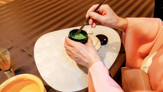 Japanese woman preparing matcha tea in traditional ceremony