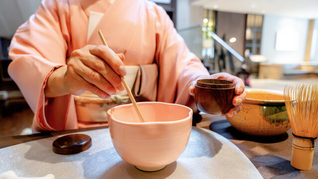 Japanese woman preparing matcha tea in traditional setting