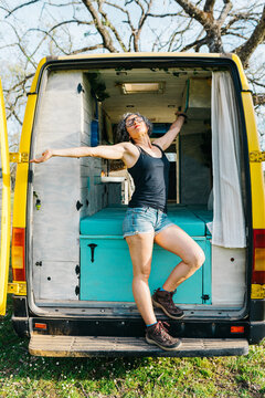 Woman enjoying holiday freedom in camper van doorway
