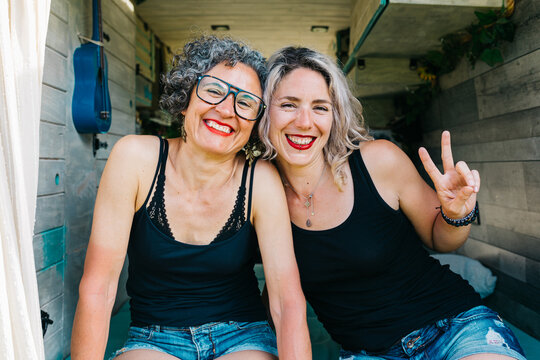 Two happy women relaxing in a camper on holiday trip