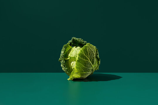 Fresh Savoy cabbage on green background