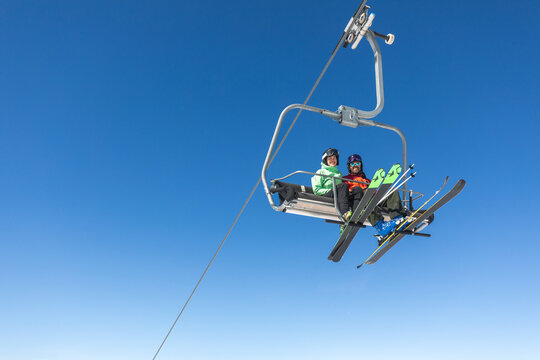 Couple on a ski lift in snowy mountain landscape