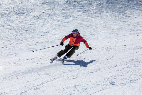 Skiing enthusiast carving through snowy mountain slope