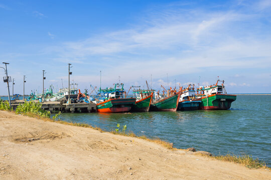 Fishing boats moored at Banda Aceh harbor under blue sky