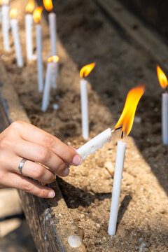 Woman lighting candle at wish wall in Ephesus, Turkey