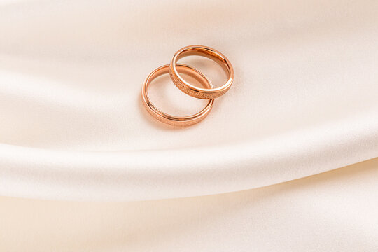 Elegant wedding rings on satin fabric