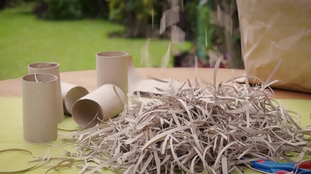 Paper shavings falling onto a garden table for composting