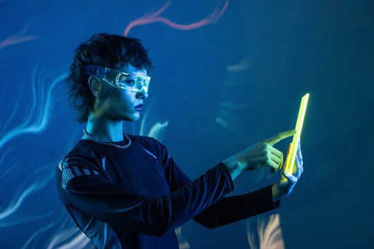 Cyberpunk young woman using vr glasses and tablet