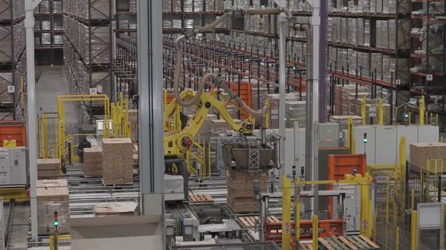 M&aacute;quina industrial automatizada moviendo cajas en f&aacute;brica, sistema de transporte y manipulaci&oacute;n de materiales en planta de producci&oacute;n