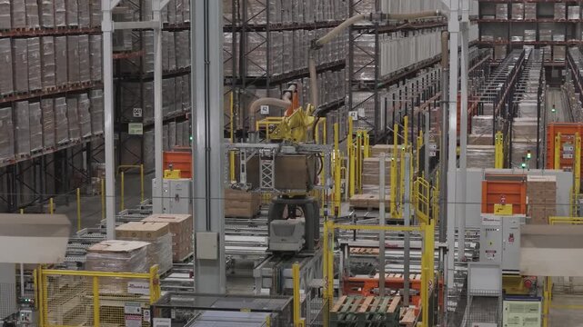 M&aacute;quina industrial automatizada moviendo cajas en f&aacute;brica, sistema de transporte y manipulaci&oacute;n de materiales en planta de producci&oacute;n