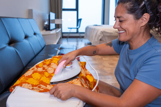 Woman ironing clothes as part of daily routine