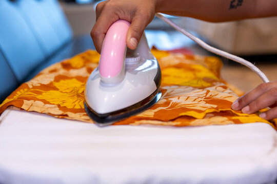 Person ironing clothes on board as part of daily routine