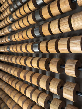 Abstract wood cylinder pattern with metal spacers on wall