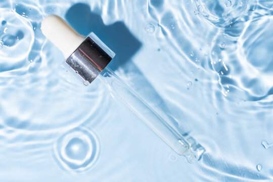 Pipette dropper floating on rippling water surface