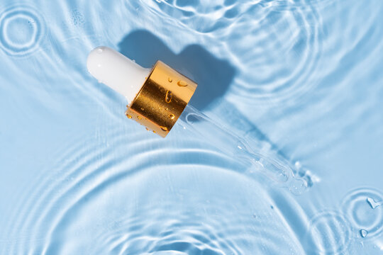 Dropper and water creating ripples in blue surface