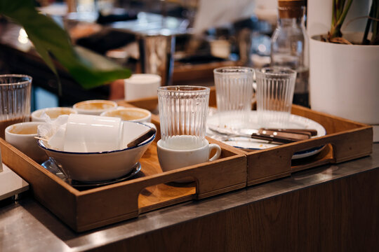 Cafe tray with used dishes, glasses and cutlery on counter