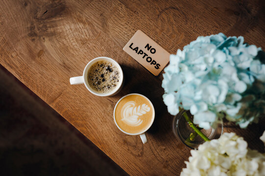Cozy cafe coffee on rustic table with no laptop sign