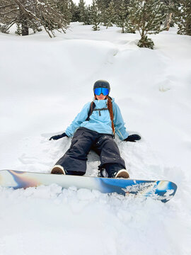 Snowboarder resting in deep snow during winter in Andorra