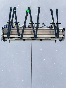 Ski lift chair with skis in snowfall, Andorra winter