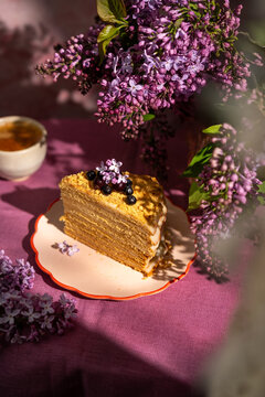 Homemade honey cake with lilac flowers and berries