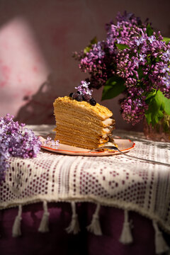 Honey cake with lilac flowers and berries