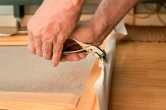 Stretching canvas on wooden stretcher frame with stapler