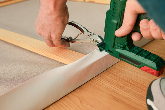 Canvas stretching with staple gun on wooden stretcher bar