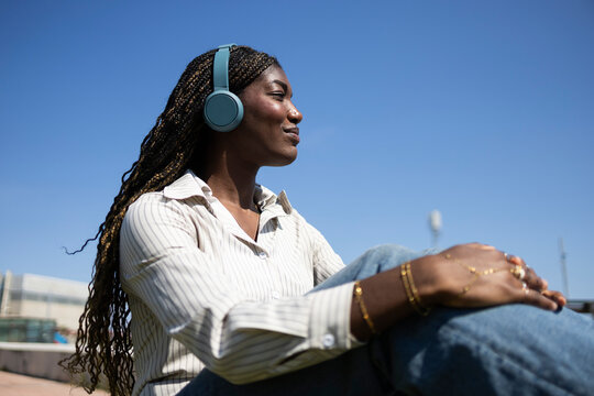Woman enjoying music outdoors with headphones