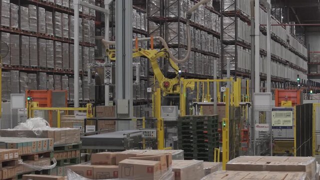 M&aacute;quina industrial automatizada moviendo cajas en f&aacute;brica, sistema de transporte y manipulaci&oacute;n de materiales en planta de producci&oacute;n