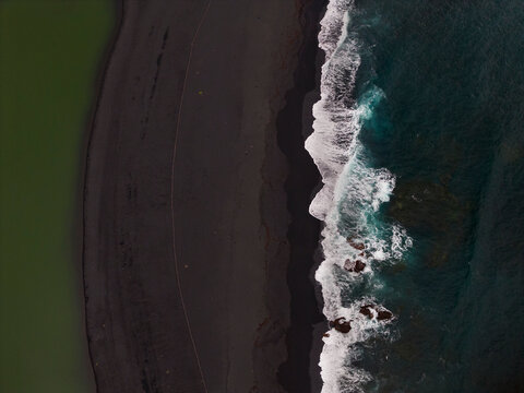 Aerial view of dramatic coastline with waves and sand