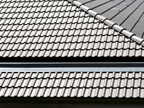 Grey roof tile pattern with ridge cap on modern building